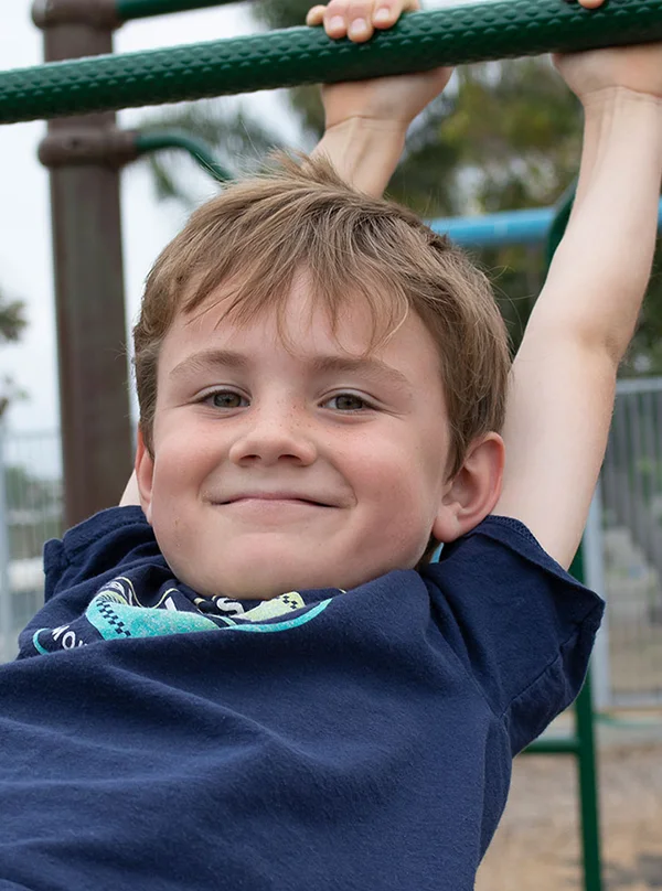 little boy on monkey bars